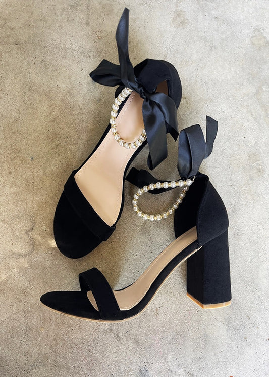 Trish Pearl Ankle Strap Bow Faux Suede Heels in Black